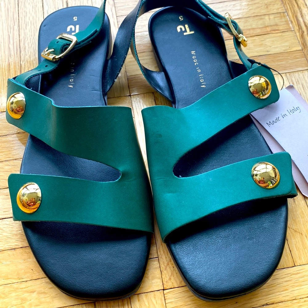 Green and black flat sandal with gold accents.